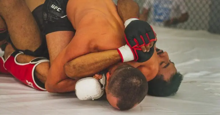 Two MMA fighters grappling on the mat, illustrating core ground control concepts in our BJJ positions explained guide.