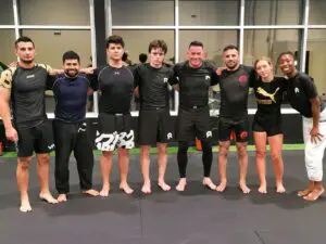 Adult BJJ students posing together after no-gi training at the academy demonstrating what to wear to BJJ class